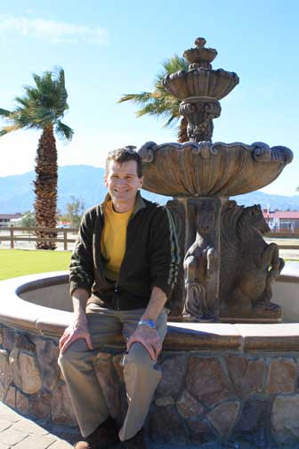 Portrait of Tom Struzzieri sitting on a fountain at the HITS Desert Horse Park.