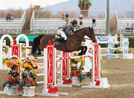 Markus Beerbaum and Lancero clear a bright red and white oxer.